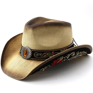 Detail of western straw hat with floral embroidery and vintage silver buckle with amber stone