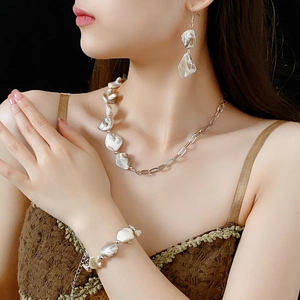 Détails d'une parure en nacre irrégulière avec collier, boucles d'oreilles et bracelet sur mannequin