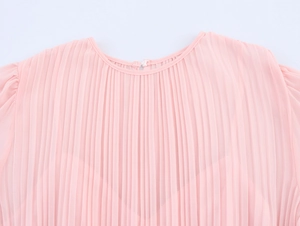 Close-up of pink pleated chiffon dress neckline with elegant gathered fabric details