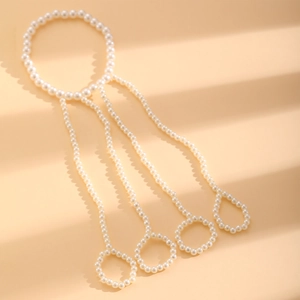 Detail of multi-layer faux pearl ring bracelet set with integrated finger chain design