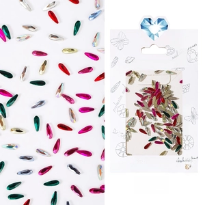 Macro view of colorful teardrop nail art rhinestones set in white hanging card packaging