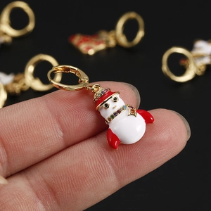 Detailed view of a gold Christmas snowman earring featuring red enamel and colorful rhinestones