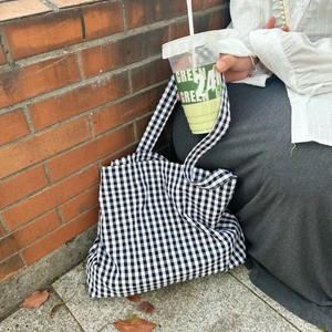 Detail of classic black and white gingham tote bag featuring durable canvas material