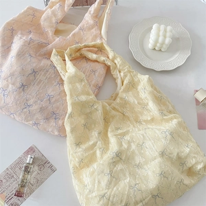 Gros plan de sacs cabas en toile jaune et orange avec motifs de nœud papillon