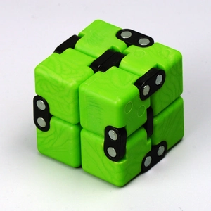 Macro detail of a green infinity cube stress relief toy with black folding hinges
