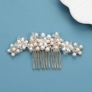 Detail of handmade bridal hair comb with white pearls and crystals on a gold base