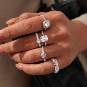 Close-up of stacked silver-tone rings featuring zircon stones in square and round shapes