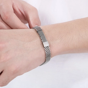 Close-up of a silver woven snake bone chain bracelet on a male wrist in a minimal style