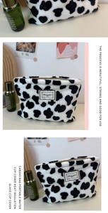 Close-up of cow print plush coin purse featuring a black and white Time to Party label