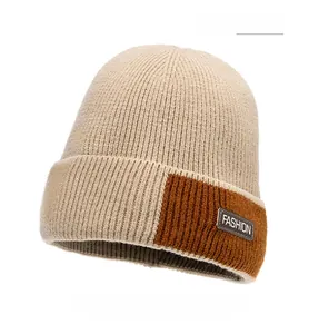 Detail of light khaki ribbed knit beanie with Fashion leather patch and color contrast
