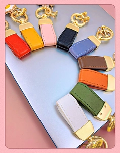 Detailed flat lay of colorful leather keychains with gold D-ring and metal clasp