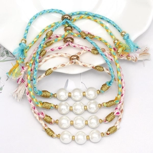 Detailed macro shot of four colorful braided pearl bracelets with adjustable silk tassels