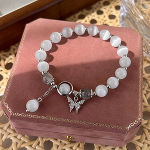 Detailed view of beaded bracelet with cat eye stones and crystal butterfly pendant