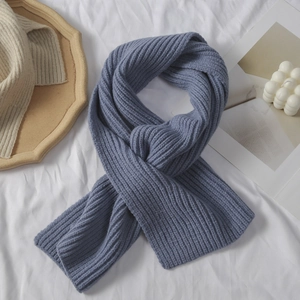 Detail eines blauen Strickschals mit vertikalen Streifen und beigefarbenem Modell