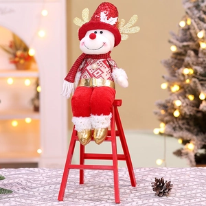 Close-up of a Christmas plush doll in red sequins sitting on a miniature red ladder