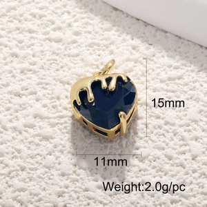 Detail of 18K gold heart pendant with deep blue gemstone and melted gold texture