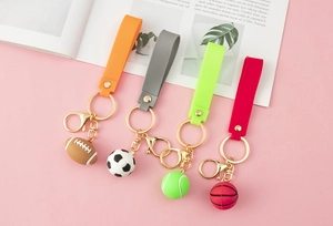 Flat lay detail of colorful sports ball keychains including soccer, basketball and tennis