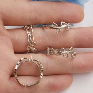 Macro detail of silver heart-shaped ring mount for DIY jewelry with leaf accents