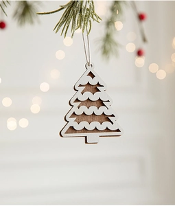 Close-up of a dual-layer wooden Christmas tree ornament with white laser-cut detail