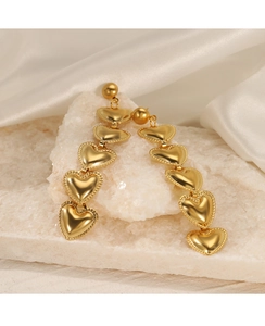 Detail of gold drop earrings with five cascading hearts and beaded edges on silk