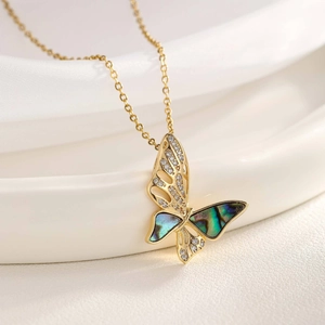 Detail of gold butterfly necklace featuring shimmering shell inlay and sparkling zircons