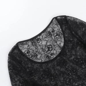 Gros plan sur la dentelle florale et l'encolure ronde de ce haut noir transparent