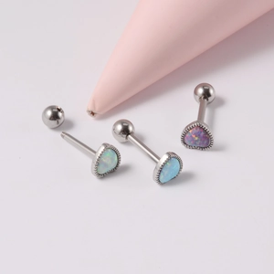 Détail de piercings de langue en opale en forme de cœur blanc, bleu et rose