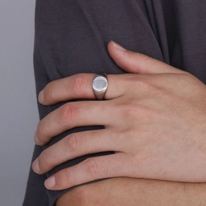 Close-up of a silver stainless steel signet ring worn on a finger for a minimalist style