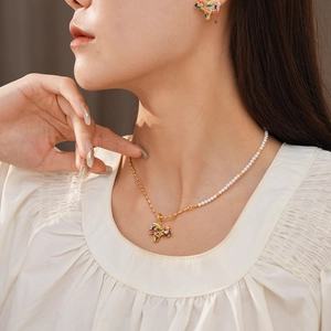 Close-up of vintage style pearl and gold necklace with colorful zircon unicorn pendant