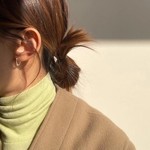 Minimalist 925 sterling silver oval stud earrings worn by a model in a natural setting