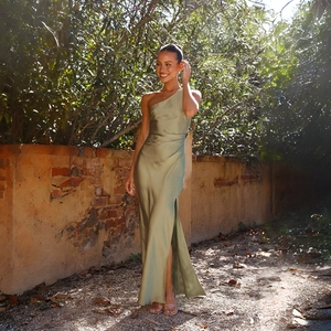 Detail of elegant olive green one-shoulder satin dress with high side slit and drape