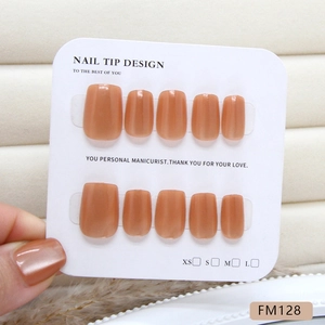 Handmade amber cat-eye press-on nails in nude milk tea tones on a white display card