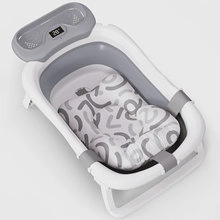 Macro shot of smart digital thermometer on a gray and white folding baby bathtub
