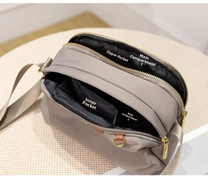 Internal view of khaki nylon crossbody bag showing dual main compartments and zipper pocket