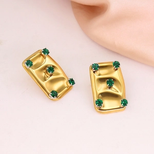 Macro shot of 18K gold plated rectangular earrings with five sparkling green gemstones