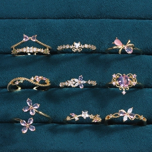Collection détaillée de bagues dorées avec zircons roses en forme de fleur et papillon