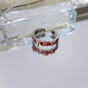 Macro shot of silver alloy ring with red enamel heart and 3D bowknot design details