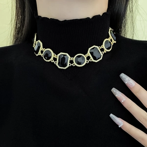 Vintage gold choker necklace with black rectangular and round geometric gemstones on model