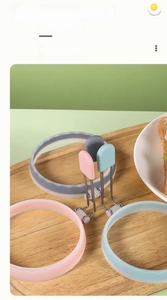Tre anelli per uova in silicone rosa, blu e grigio con manici isolati in acciaio inox