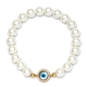 Close-up of shell pearl bracelet with gold evil eye charm and sparkling crystals