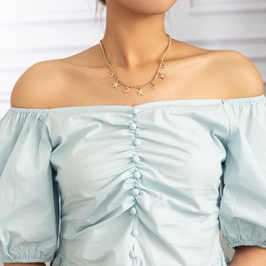 Detail of layered gold star and moon necklace with sparkling crystals on a model