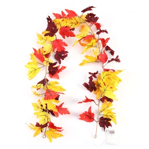 Close-up of realistic maple leaf string lights with battery box on a plain white background