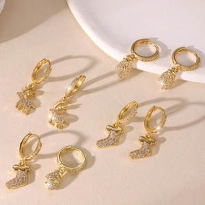 Boucles d'oreilles de Noël plaquées or 14k avec rennes et zircons sur fond beige