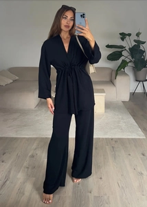 Detail of black long-sleeved tie-front top and wide-leg pants two-piece set