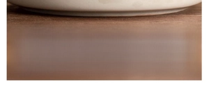 Macro shot of smooth and flat ceramic mug base ensuring stable placement on a wood table