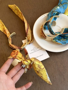Macro detail of retro silk-wrapped bangle featuring Van Gogh artistic prints and bead trim