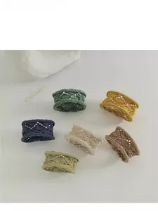 Détail de six chouchous tricotés évidés colorés en vert, jaune, bleu marine et beige