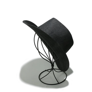 Detail of black straw fedora showing fine weave texture on a minimalist hat stand