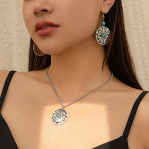 Detail of vintage bohemian silver necklace and earrings with turquoise stone inserts