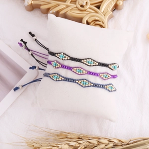 Bohemian hand-woven seed bead bracelets in black, purple, and blue with gold accents